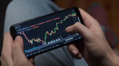 Telefon ve bilgisayar kullanarak bitcoin kripto parası ticareti yapan bir yatırımcı.