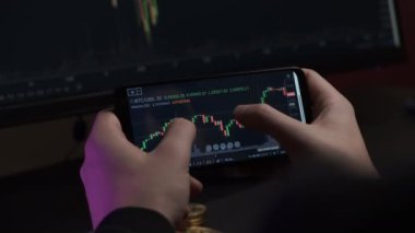 Yatırım komisyoncusu telefon kullanarak bitcoin şifreli para ticareti yapıyor.