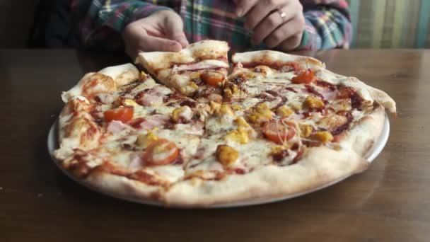 İnsan eli sıcak İtalyan pizzasından dilimler alıyor. — Stok video