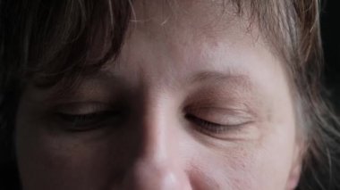 Yaşlı kadının yüzü ve gözleri. Yüzünde büyük kırışıklıklar var. Kapat.