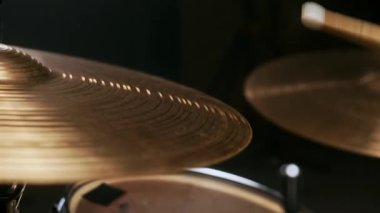 Müzisyen perküsyon ziline basıyor. Rocker karanlık bir stüdyoda müzik yaratıyor..