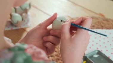 Bir kadın Paskalya yumurtalarını boyuyor. Arkadan görüntüle.