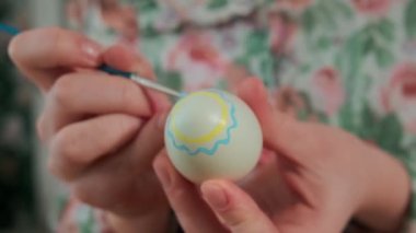 Kadın, Paskalya yumurtalarını renkli boyalarla boyuyor, yakın plan.