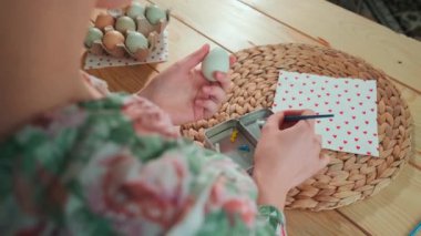 Bir kadın Paskalya yumurtalarını boyuyor. Arkadan görüntüle.