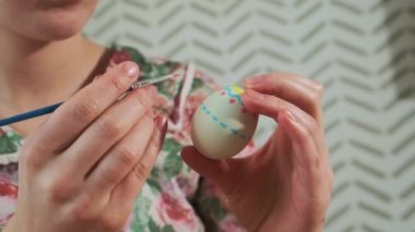 Kadın, Paskalya yumurtalarını renkli boyalarla boyuyor, yakın plan.