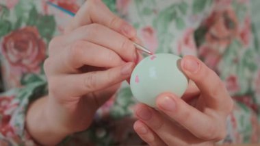 Kadın, Paskalya yumurtalarını renkli boyalarla boyuyor, yakın plan.