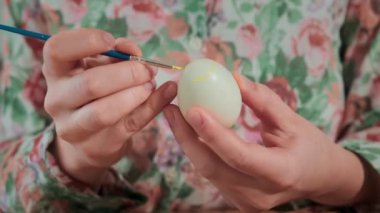 Kadın, Paskalya yumurtalarını renkli boyalarla boyuyor, yakın plan.