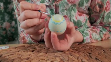 Kadın, Paskalya yumurtalarını renkli boyalarla boyuyor, yakın plan.