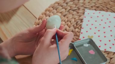 Bir kadın Paskalya yumurtalarını boyuyor. Arkadan görüntüle.