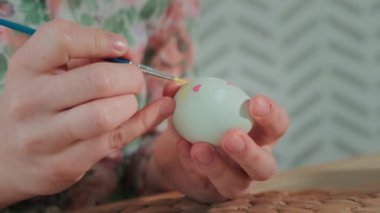Kadın, Paskalya yumurtalarını renkli boyalarla boyuyor, yakın plan.