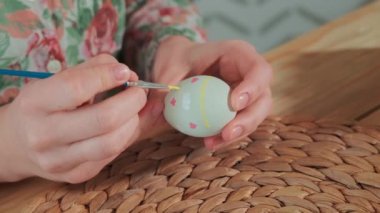 Kadın, Paskalya yumurtalarını renkli boyalarla boyuyor, yakın plan.