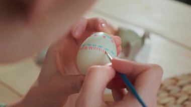 Bir kadın Paskalya yumurtalarını boyuyor. Arkadan görüntüle.