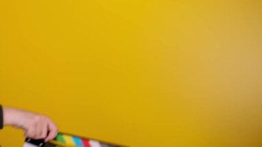 Siyah arkaplan üzerinde el çırpma tahtası kullanan erkek eller, film çekiyor.