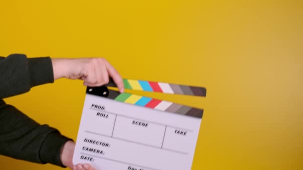 Tangan laki-laki menggunakan clapperboard terhadap latar belakang hitam, syuting film — Stok Video