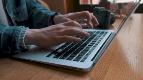 Een close-up. De handen van een jonge zakenman typen tekst op het toetsenbord van een laptop — Stockvideo