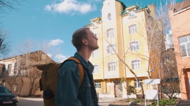 Samiec podróżnika z żółtym plecakiem robi zdjęcia miastu przed kamerą. — Wideo stockowe