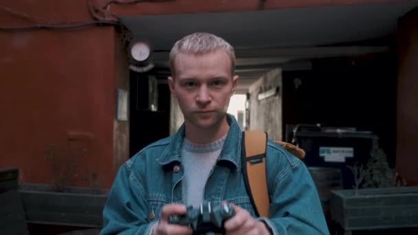 Молодой человек использует винтажную камеру для фотографирования. — стоковое видео