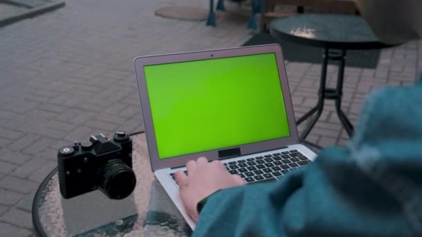 Fotografen arbejder på en bærbar computer med en grøn skærm. . – Stock-video