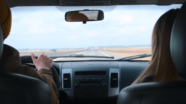 Una joven pareja viaja en coche. Vista desde el coche. — Vídeo de stock