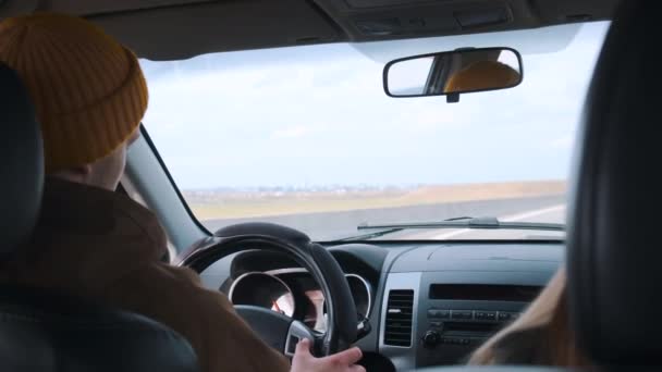 Ein junges Paar ist mit dem Auto unterwegs. Blick aus dem Auto. — Stockvideo