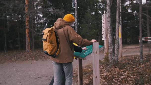 Una pareja joven de viajeros que exploran el mapa del bosque. Encontrar la ruta — Vídeos de Stock