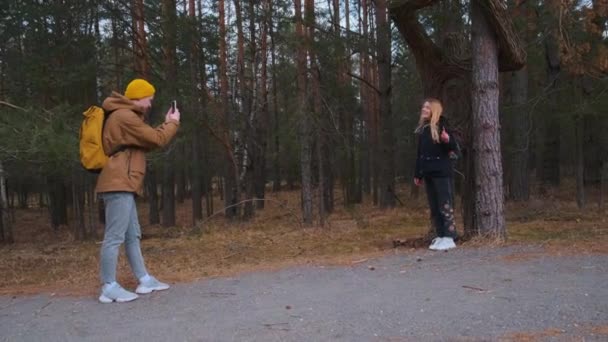 Junges Paar von Reisenden oder Touristen, die Fotos machen, während sie den Wald erkunden. — Stockvideo