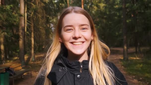 Joven feliz hermosa hembra sonriendo de pie en el camino del bosque. Viajar. — Vídeos de Stock