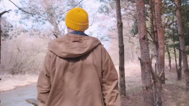 Tylna rama młodego podróżnika z żółtym plecakiem spacerującego po lesie. — Wideo stockowe