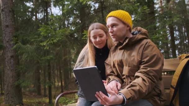 아름다운 두 명의 명의 명의 남녀 가 숲 속을 여행하는 동안 비디오를 찍고 있습니다. — 비디오