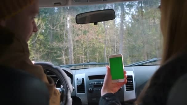 Молодая пара путешествует на автомобиле, используя навигацию и карты в лесу. Greenscreen — стоковое видео