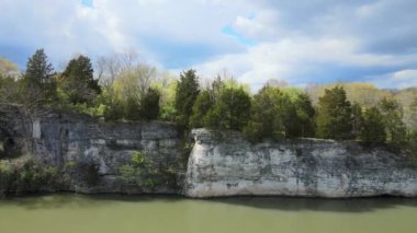 Gün batımında nehir kenarındaki beyaz bir uçurumun havadan görünüşü.