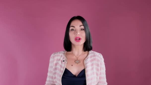 Una donna rilascia un'intervista su sfondo rosa. Una donna registra un video per il suo video. — Video Stock