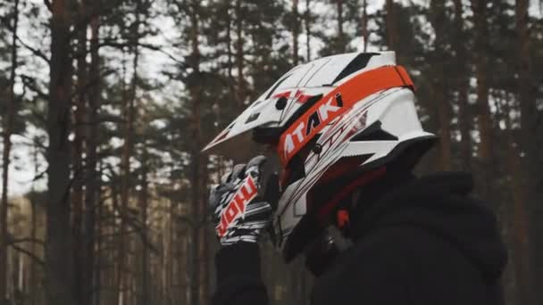 Uma grande foto de um motociclista a usar um capacete. Motociclista está indo para ir em uma estrada florestal difícil. — Vídeo de Stock