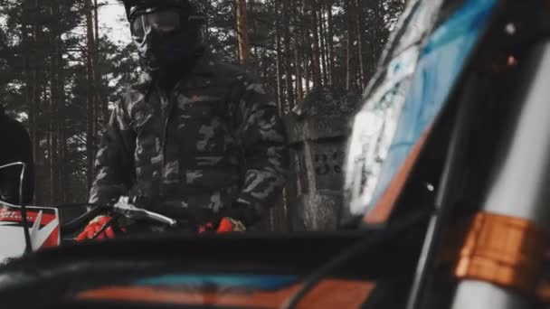 Uma grande moldura dos faróis de uma motocross motocicleta contra o fundo de um motociclista e um pólo. Motocross na floresta. — Vídeo de Stock