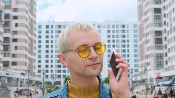 노란 안경을 쓰고 카메라를 보고 있는 매력적 인 금발의 유럽 사람의 초상화. — 비디오