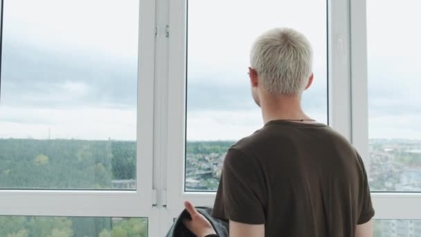 Jovem empresário europeu vestindo uma jaqueta em frente a uma enorme janela panorâmica. Preparação para uma reunião de negócios. — Vídeo de Stock
