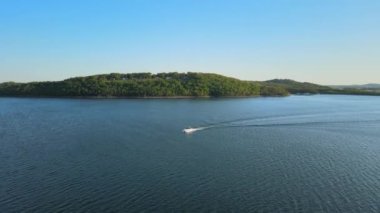 Hava kuşları, batan güneşin altındaki bir nehir koyunu ve yeşil yağmur ormanlarını izliyor..