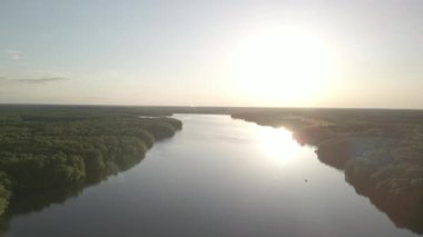 Hava kuşları, batan güneşin altındaki bir nehir koyunu ve yeşil yağmur ormanlarını izliyor..