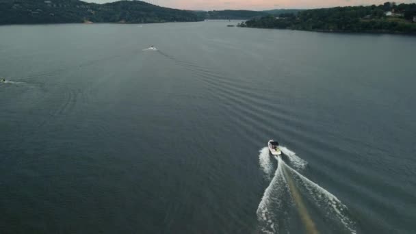 The boat slowly sails along a large river against the backdrop of sunset. Shot on a drone. — Stock video