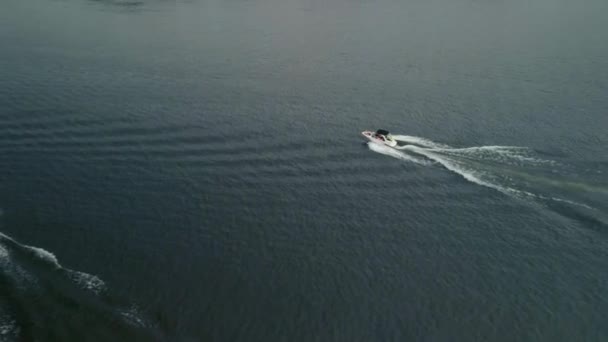O barco navega lentamente ao longo de um grande rio contra o pano de fundo do pôr do sol. Atingido num drone. — Vídeo de Stock