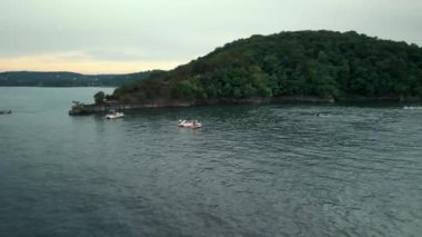 Gençler göletin kenarında tekne ve jet ski sürerken iyi vakit geçiriyorlar..