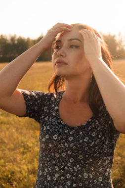 Buğday tarlasında uzun siyah saçlı mutlu bir kız. Hayatının mutlu anlarından zevk alıyor..