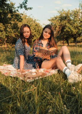 İki kız kardeş doğada yürüyor ve iletişim kuruyor. Gün batımında fotoğraf çekiyorlar..