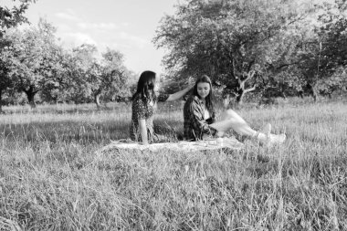 İki kız kardeş doğada yürüyor ve iletişim kuruyor. Gün batımında fotoğraf çekiyorlar..