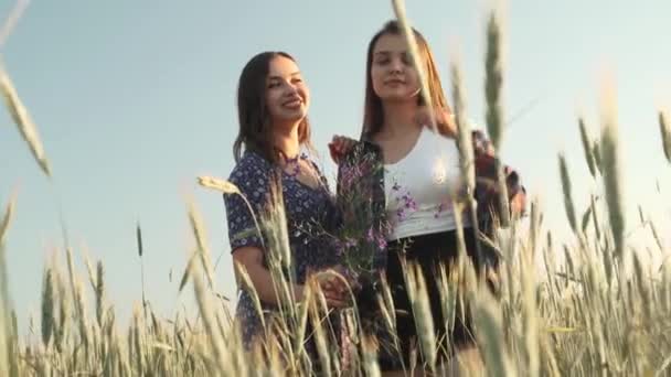 Twee zussen lopen in de natuur en communiceren. Ze maken foto 's bij zonsondergang.. — Stockvideo