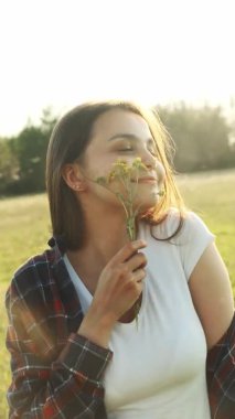 Genç bir kız doğadayken anın tadını çıkarır. Dikey video.