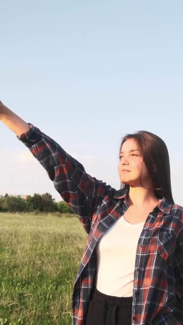 Uma jovem gosta do momento enquanto está na natureza. Vídeo vertical. — Vídeo de Stock