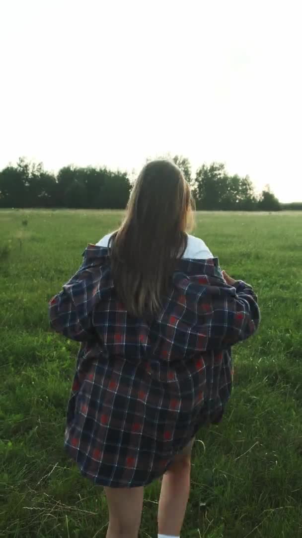 Uma jovem gosta do momento enquanto está na natureza. Vídeo vertical. — Vídeo de Stock