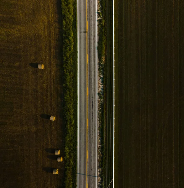 Boş bir yolun kuş bakışı görüntüsü, tarlanın hemen yanında..