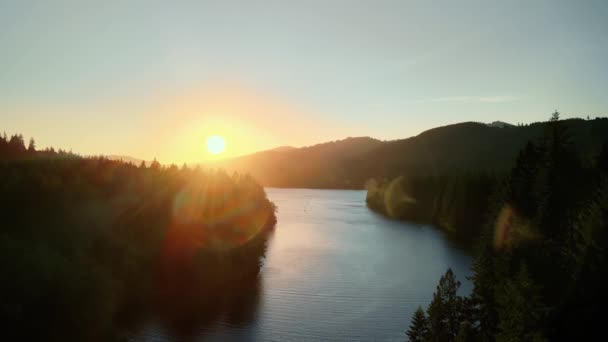 Fågelperspektiv på soluppgången över floden med kuperad terräng. — Stockvideo